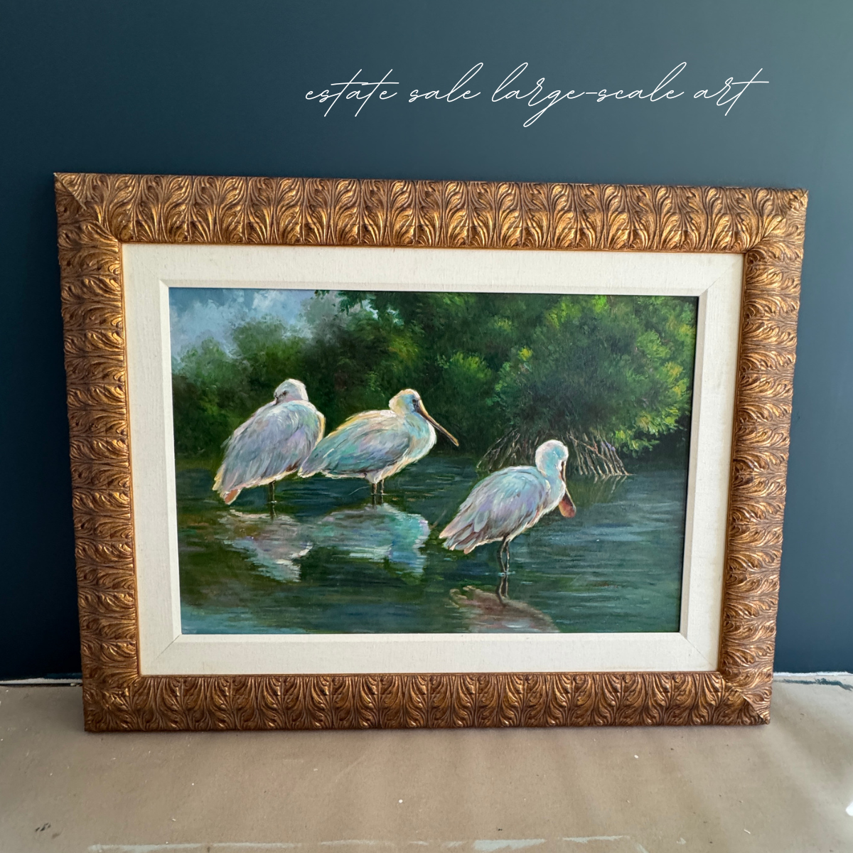 Framed estate sale painting of three spoonbill birds wading at a lake's edge